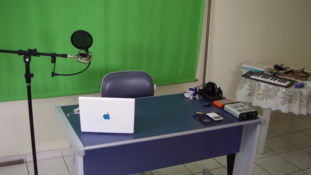 Twee sprekers aan een podcasttafel met microfoons, opgenomen door twee camera's