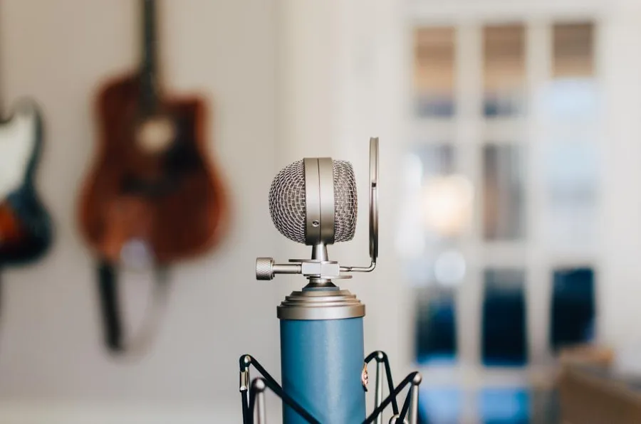 Condensatormicrofoon in een huiskamer met een gitaar aan de muur