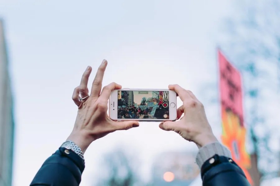 Handen die met een smartphone een video opnemen