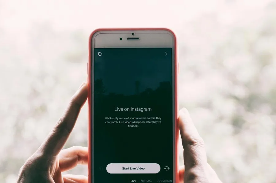 Hand met smartphone die een livevideo start